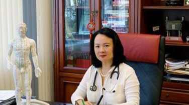 Dr. med. Jü Tang an ihrem Schreibtisch in der Praxis